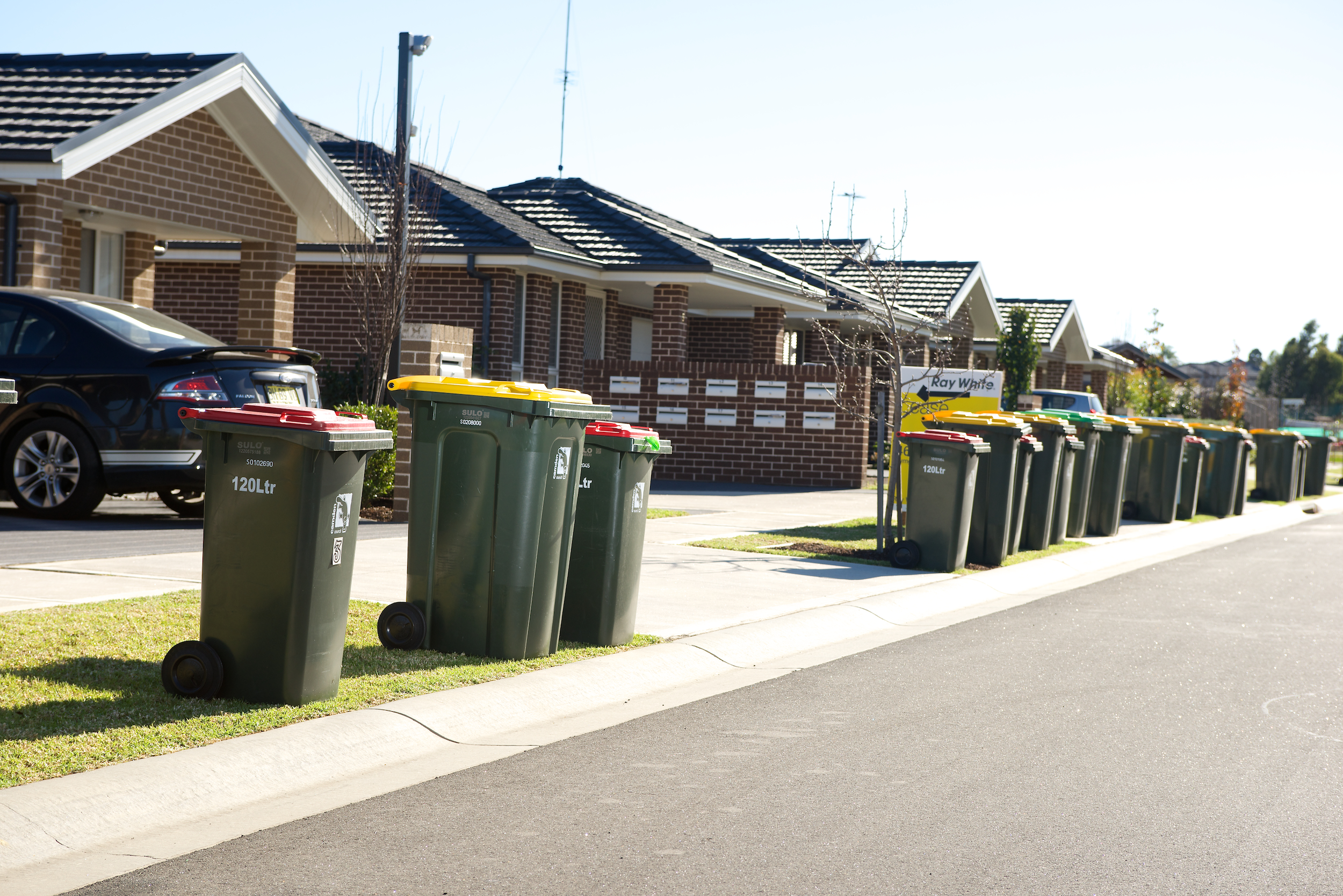 View of a street which has garbage bins placed on the kerb